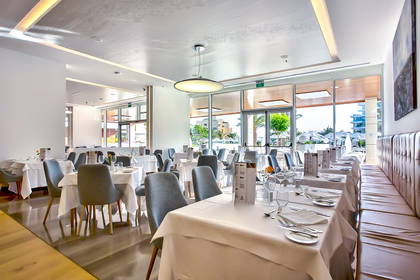 Elegancka restauracja z nakrytymi stołami.