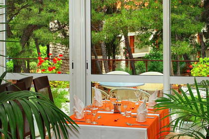 Wnętrze restauracji z widokiem na zieleń.