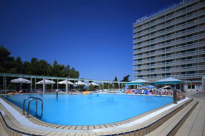 Hotel z basenem i leżakami do opalania.