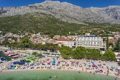 Plaża z hotelem w otoczeniu gór.