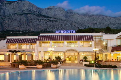 Hotel Afrodita z basenem i widokiem na góry.