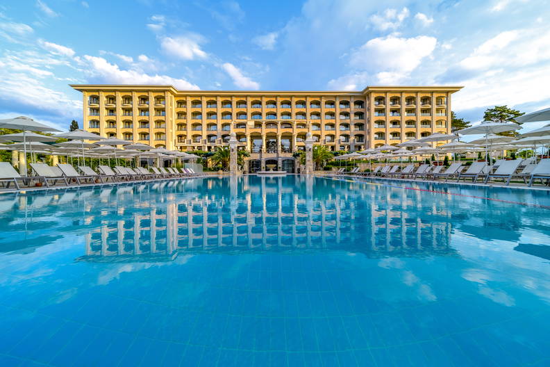 Hotel z basenem i leżakami do opalania.