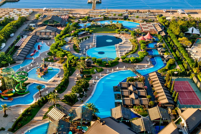 Kompleks hotelowy z basenami, parkiem wodnym i plażą, widok z lotu ptaka.