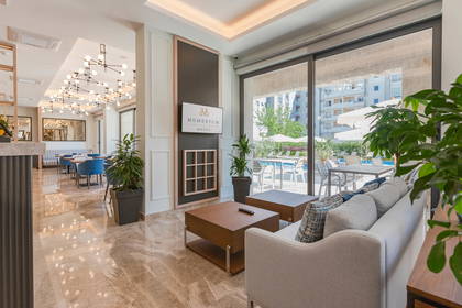 Wnętrze hotelu. Sofa i widok na basen.
