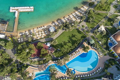 Hotel z basenami i plażą widziany z góry.