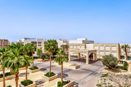 Hotel Hilton z palmami i dziedzińcem.