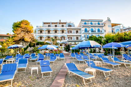 Plaża z leżakami i parasolami przy hotelu.