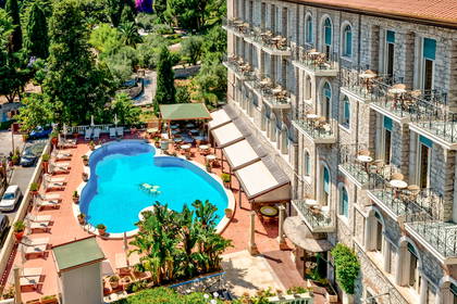 Hotel z basenem i balkonami, widok z góry.
