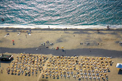Plaża z lotu ptaka, widoczne parasole i leżaki.