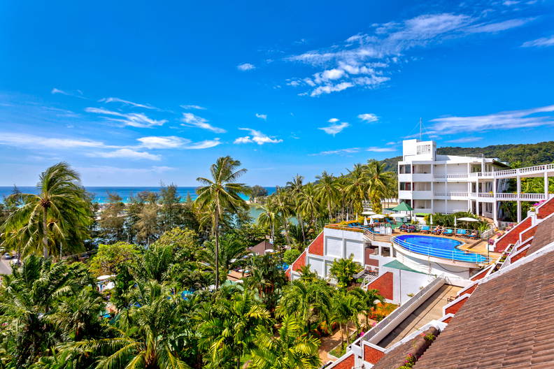 Tropikalny kurort z basenem i palmami w słoneczny dzień.