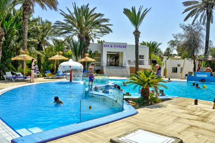 Basen z palmami obok budynku spa.
