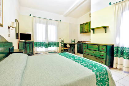 Pokój hotelowy z łóżkiem i aneksem kuchennym.