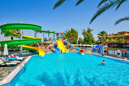Aquapark z kolorowymi zjeżdżalniami i basenem.