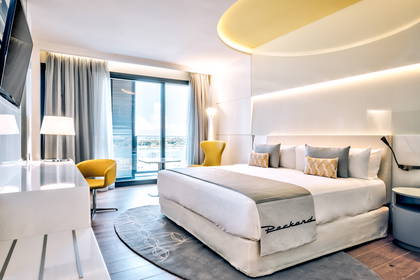 Nowoczesny pokój hotelowy z dużym łóżkiem i oknem.