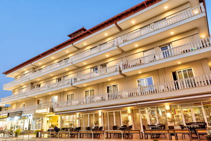 Fasada hotelu z balkonami i restauracją na poziomie parteru.
