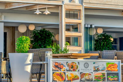 Ekspozycja menu restauracji Mandala przed budynkiem.