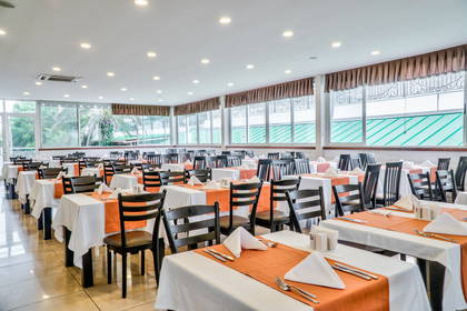 Sala restauracyjna z nakrytymi stołami.