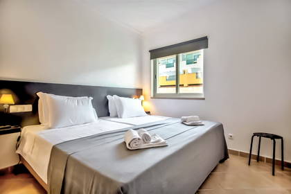 Pokój hotelowy z dwoma łóżkami, oknem i krzesłem.