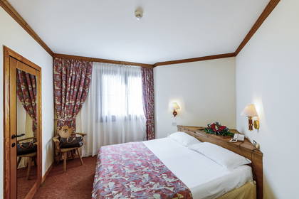 Pokój hotelowy z łóżkiem i lustrem.