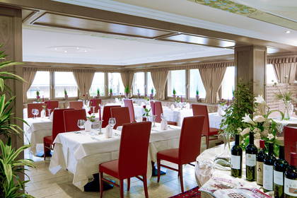 Restauracja z nakrytymi stołami i czerwonymi krzesłami.