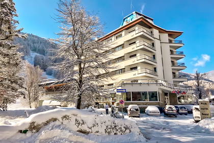 Zimowy krajobraz. Hotel i zasypane śniegiem samochody.