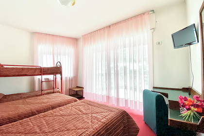Pokój hotelowy z łóżkiem piętrowym i telewizorem.