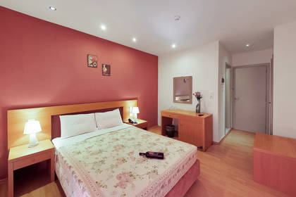 Pokój hotelowy z łóżkiem, szafkami nocnymi i biurkiem do pracy.