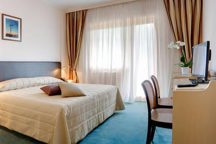 Pokój hotelowy z łóżkiem, biurkiem i krzesłami.
