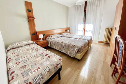 Pokój hotelowy z trzema łóżkami.