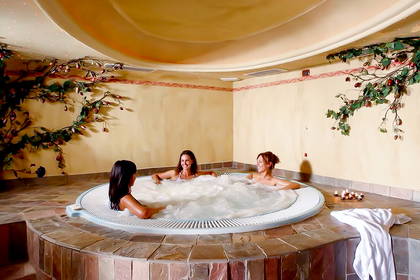 Trzy kobiety relaksują się w jacuzzi w spa.