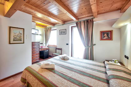 Pokój hotelowy z łazienką i drewnianym sufitem.