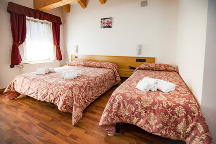 Pokój hotelowy z dwoma łóżkami i oknem.