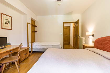 Jasny pokój hotelowy z drewnianymi meblami.