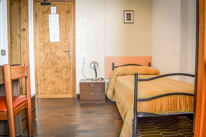 Pokój hotelowy z łóżkiem, szafką nocną i krzesłem.