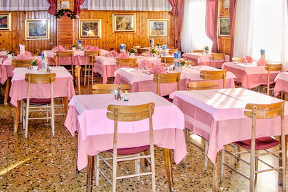 Restauracja z drewnianymi ścianami i nakrytymi stołami.