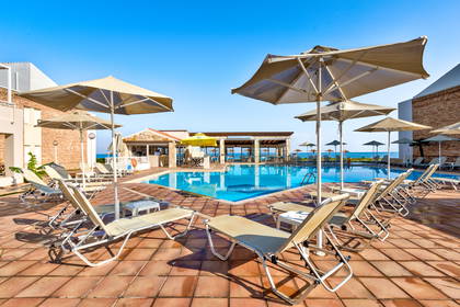 Basen z leżakami i parasolami przy hotelu.