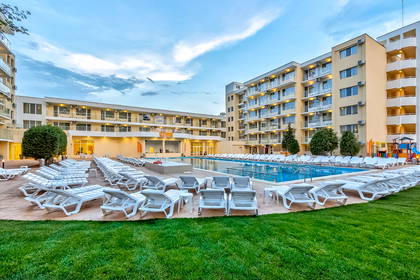 Hotel z basenem i leżakami do opalania.