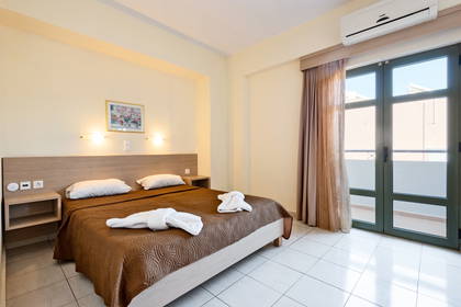 Pokój hotelowy z dużym łóżkiem i balkonem.