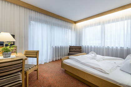 Pokój hotelowy z łóżkiem, biurkiem i krzesłami.