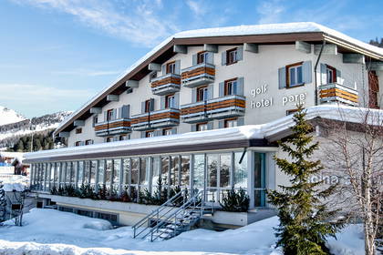 Hotel w zimowej scenerii, balkony i śnieg na dachu.
