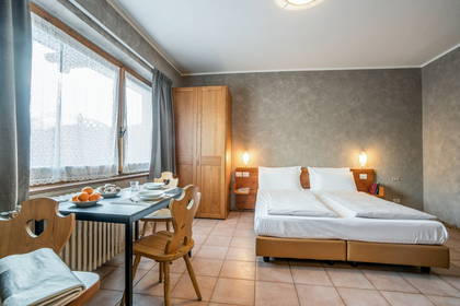 Pokój hotelowy z łóżkiem, stołem i krzesłami.