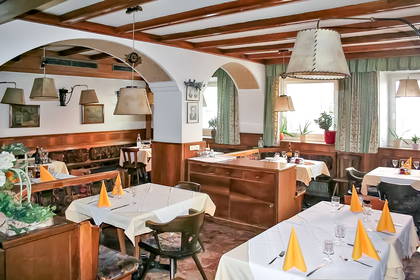 Wnętrze restauracji. Nakryte stoliki i elementy wystroju z drewna.