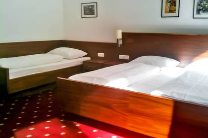 Pokój hotelowy z dwoma łóżkami i białą pościelą.