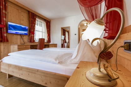 Pokój hotelowy z drewnianymi meblami i lampką nocną w kształcie kwiatka.