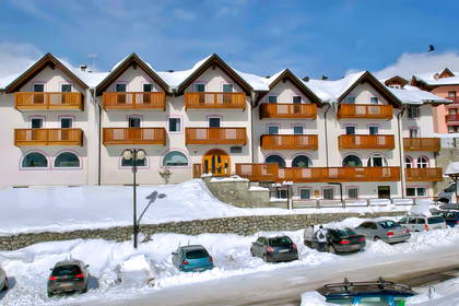 Hotel w zimowej scenerii. Parking zasypany śniegiem.