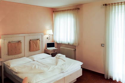 Pokój hotelowy z łóżkiem, biurkiem i oknami.