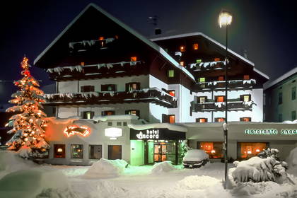 Hotel Ancona w nocy, pokryty śniegiem.