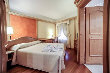 Pokój hotelowy z łóżkiem i otwartymi drzwiami.