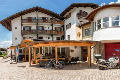 Budynek z restauracją, rowerem i motocyklem przed wejściem.
