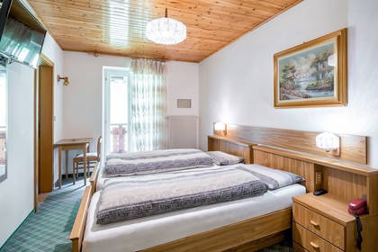 Pokój hotelowy z dwoma łóżkami, drewnianym sufitem i obrazem.